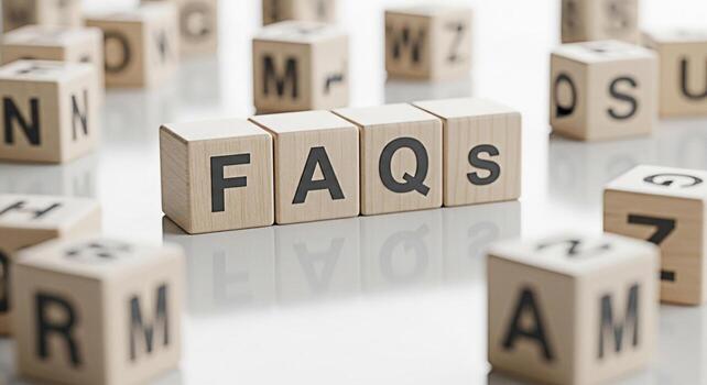 Wooden blocks spelling FAQs on a reflective surface surrounded by other lettered blocks representing frequently asked questions and providing answers in a clear and accessible manner promoting underst photo