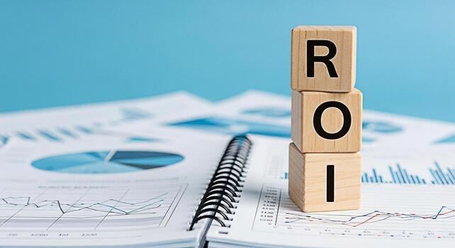 Wooden blocks displaying ROI placed on a notebook filled with financial charts and graphs against a blue background symbolizing investment analysis and the concept of return on investment for business photo