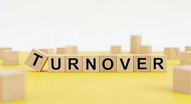 Wooden blocks spelling Turnover on a yellow surface symbolizing employee turnover in a business environment representing challenges and changes in human resources and workforce management with a focus photo