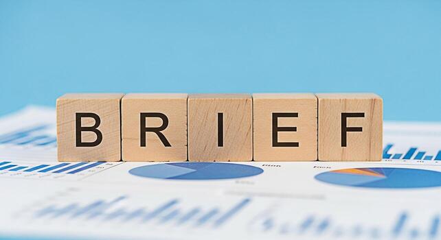 Wooden blocks spelling BRIEF placed on top of business charts against a light blue background representing concise communication and data analysis for effective decisionmaking in a corporate environme photo
