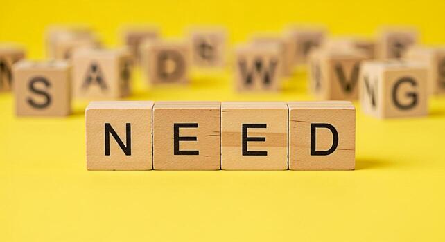 Wooden blocks spelling NEED on a bright yellow background conveying a sense of urgency and importance highlighting the concept of essential requirements and necessities in a minimalist and impactful c photo