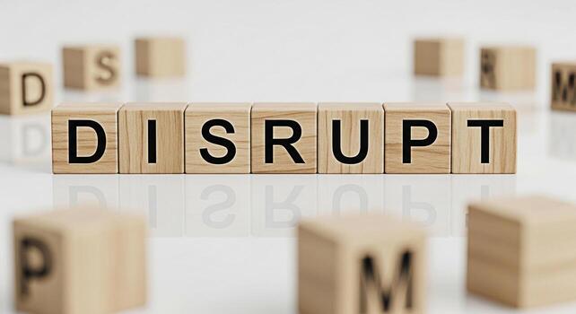 Wooden blocks spelling DISRUPT on a white surface surrounded by other lettered blocks representing innovation and change in a business environment conveying a message of transformation and breaking tr photo