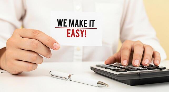 Closeup of hands holding a card that says We make it easy while using a calculator on a white desk conveying a message of simplicity and convenience in financial services and business solutions photo
