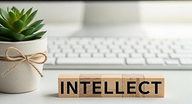 Wooden blocks spelling Intellect sit on a white desk next to a potted succulent symbolizing knowledge and intelligence in a modern workspace promoting a concept of learning and professional developmen photo