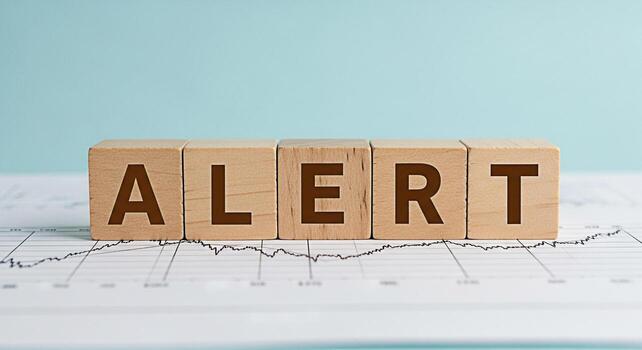 Wooden blocks spelling ALERT placed on a financial chart in a bright studio symbolizing urgent business decisions and market volatility creating a sense of awareness and the need for immediate action photo