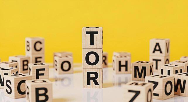 Wooden alphabet blocks spelling out the word TOR in a bright studio setting symbolizing education learning and the building blocks of knowledge with a playful and engaging mood on a yellow background photo
