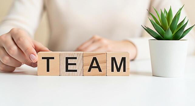 de cerca de un persona arreglando de madera bloques ortografía equipo en un blanco escritorio simbolizando colaboración y unidad en un brillante moderno oficina ambiente Fomentando un sentido de trabajo en equipo y compartido éxito foto