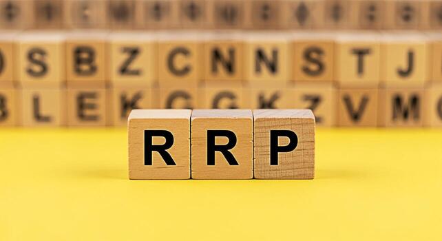 Wooden blocks spelling RRP on a vibrant yellow surface representing retail price strategy and business concepts with blurred alphabet blocks in the background conveying a sense of focus and precision photo