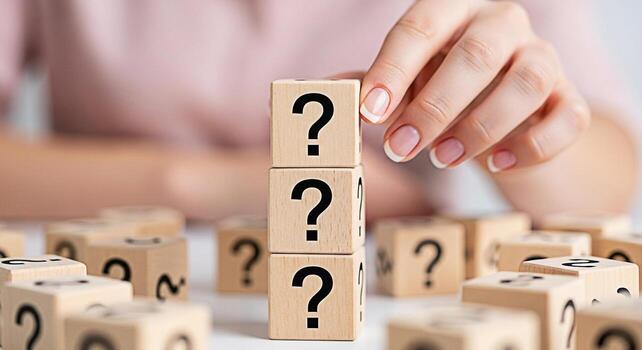 Womans hand stacking wooden blocks with question marks on a white table symbolizing uncertainty problemsolving and the search for answers in a bright and inquisitive environment fostering curiosity an photo