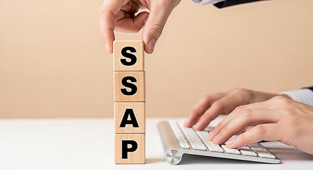 Business professional arranging wooden blocks spelling SSAP on a white desk while typing on a keyboard symbolizing strategic planning and problemsolving in a modern corporate environment conveying a s photo