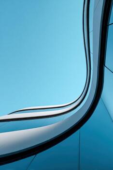 Modern building with curved lines against a clear blue sky photo