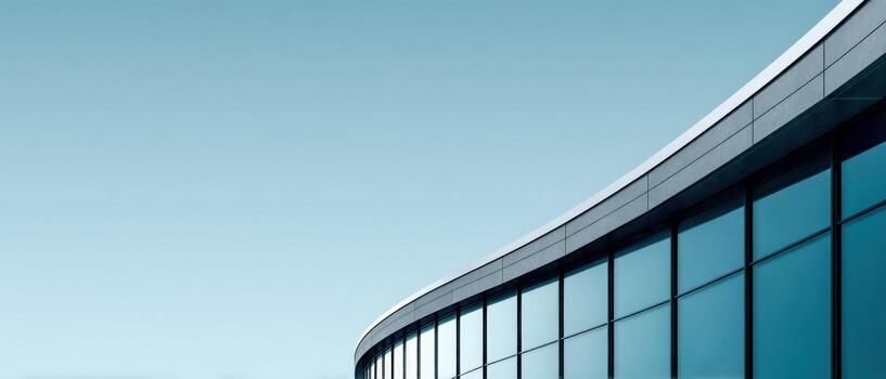 Modern building with curved glass design against clear sky photo