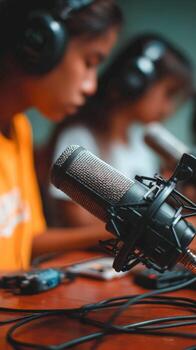 Young people engaged in a podcast recording session in a studio space photo
