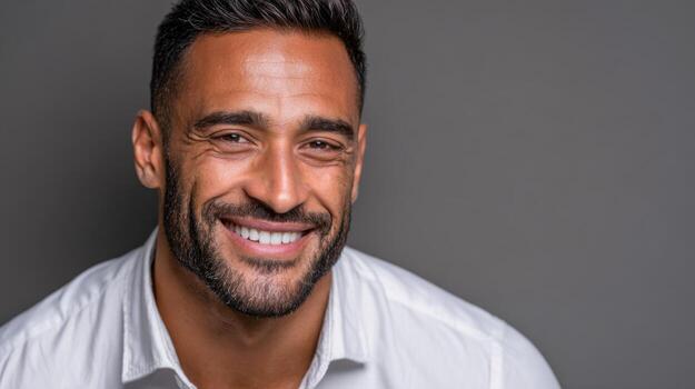Smiling team member wearing a white shirt poses against a plain background photo