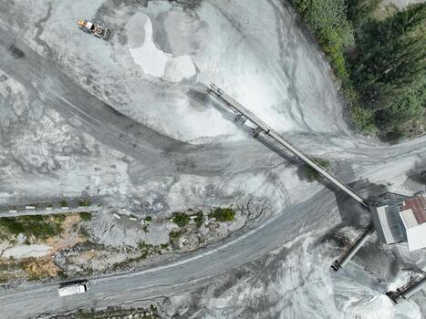 Aerial view granite and limestone crushing plant with dump truck and excavators processing raw stone into construction aggregates for concrete and infrastructure development. Stone mill factory. photo
