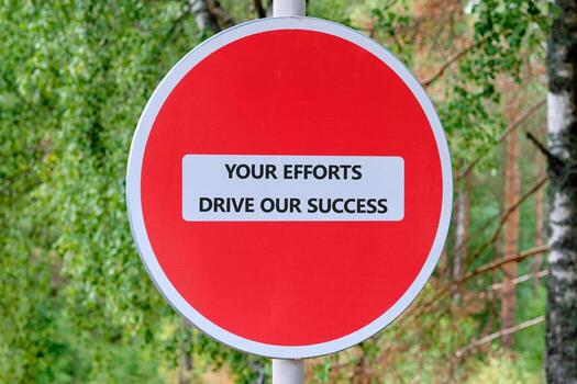 Red Circular Sign With Motivational Message Emphasizing Teamwork and Success in an Outdoor Setting Surrounded by Trees photo