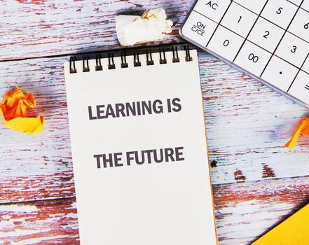Concept of Education Highlighted With a Notepad Showing the Phrase Learning is the Future Alongside Stationery Items on a Wooden Surface photo