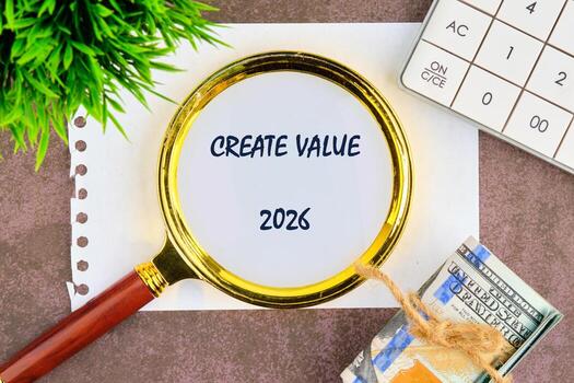 A magnifying glass rests on a note stating create value, symbolizing focus and dedication to future growth in 2026. Nearby, a calculator and cash hint at financial strategies photo