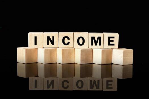 Wooden blocks arranged to spell out the word income create a striking visual against a glossy black background, emphasizing financial themes and concepts of wealth photo