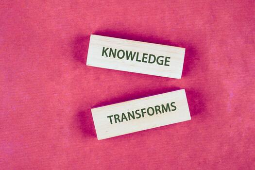Knowledge learning innovation concept. KNOWLEDGE TRANSFORMS words assembled from blocks on a crimson background, top view photo