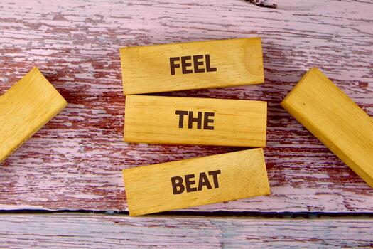 Tres de madera bloques son apilado, ortografía fuera sensación el derrotar. adicional bloques rodear el central pila. todas descanso sobre un resistido superficie con pistas de rojo y blanco pintar foto