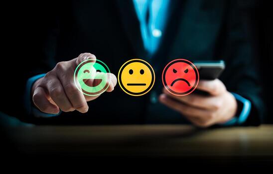 Customer satisfaction feedback concept showing person using mobile phone to select emotion face rating with happy, neutral, sad smiley icons representing service review and user experience evaluation photo