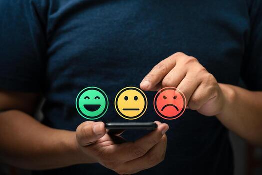 Customer satisfaction feedback concept showing person using mobile phone to select emotion face rating with happy, neutral, sad smiley icons representing service review and user experience evaluati photo