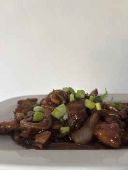 Ayam kecap, chicken with soysauce on white plating side view photo