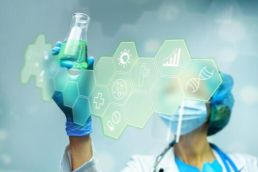 Scientist in lab holding a flask with green liquid and using technology for research photo
