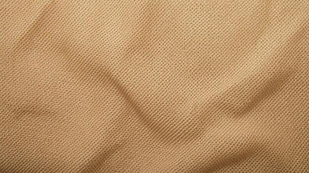 A close-up of beige woven fabric reveals a textured surface with soft folds creating subtle shadows, perfect for backgrounds and designs. photo