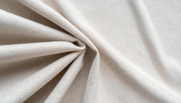 Close up view of a soft beige colored knitted fabric with interesting folds and textures creates a warm and inviting background element. photo