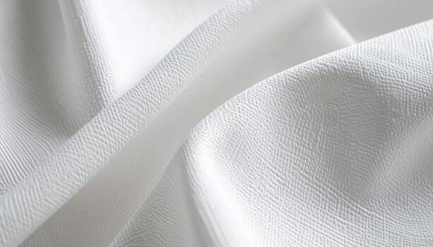 Soft white fabric gently drapes into elegant folds, showcasing a subtle textured pattern that adds depth and visual interest to the material. photo