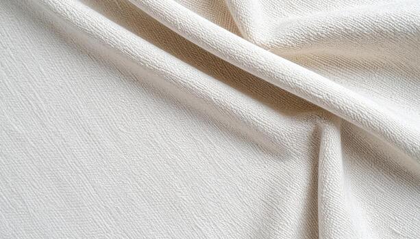 The soft off white fabric with subtle texture creates a gentle curve that suggests elegance and refined simplicity of natural material. photo