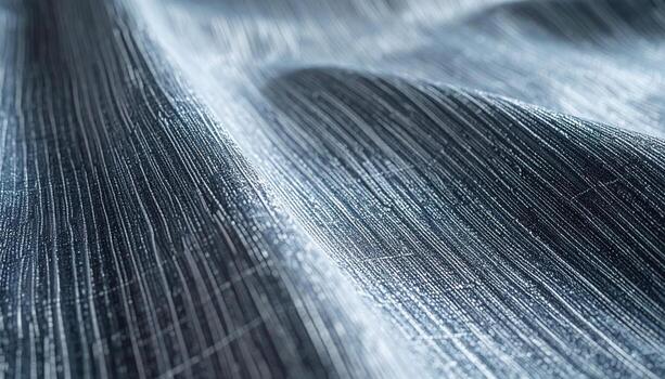 Abstract macro photograph presents a textured surface with undulating ridges and fine linear details in shades of cool silver and blue tones. photo