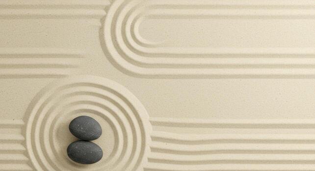 Calming zen garden arrangement with smooth gray stones placed on raked sand displaying concentric circles and flowing lines for meditation. photo