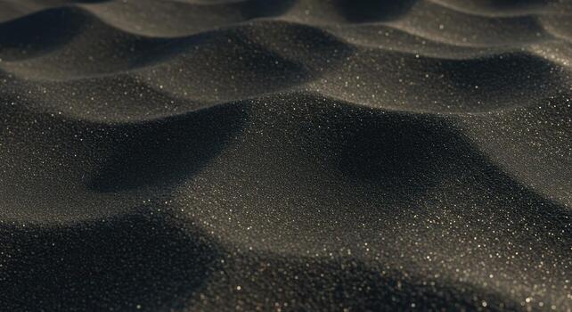 A textured black foam surface curves in a repeating wave pattern, catching the light and creating subtle highlights and shadows on its surface. photo