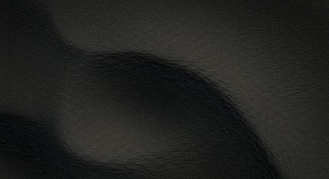 Dark waves undulate across a smooth, glossy surface creating abstract patterns in subtle gradients of black color and texture for backgrounds. photo