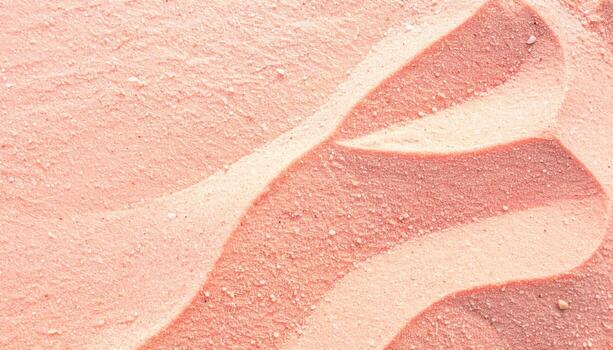 A textured surface displays swirling patterns in shades of pink and beige creating a soothing and visually appealing abstract background. photo