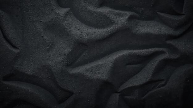 Dark sand dunes create an abstract desert landscape with textured patterns and rippled shadows in a monochromatic neutral tone image. photo