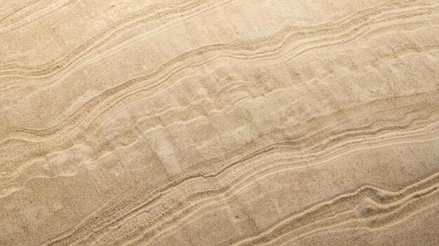 A close up shows the elegant natural wavy patterns and textured surface of a smooth stone slab in various shades of tan and brown color. photo