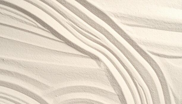 Wavy patterns delicately etched in fine white sand create a soothing Zen garden background for peaceful meditation and mindful relaxation. photo