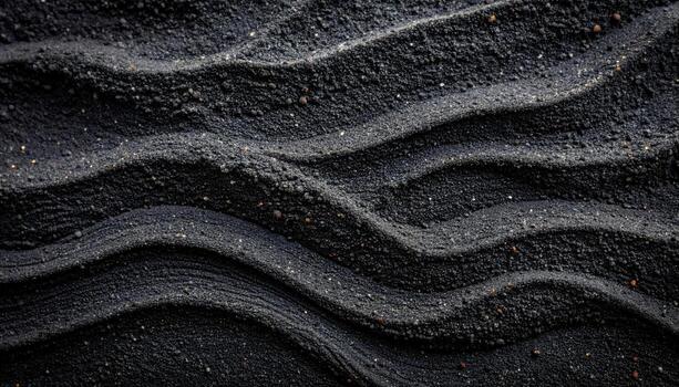 An abstract textured background features curving parallel lines through black sand, creating a rippled, flowing wave pattern on surface. photo