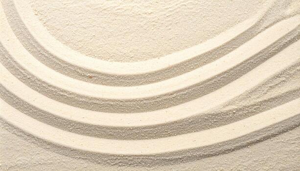 Top view reveals an abstract pattern formed by curved lines carefully raked into the fine grains of a light beige sand surface texture design. photo