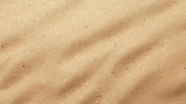 Top view of sandy beach with patterns created by waves, showing texture and natural abstract design with light and shadows on surface. photo