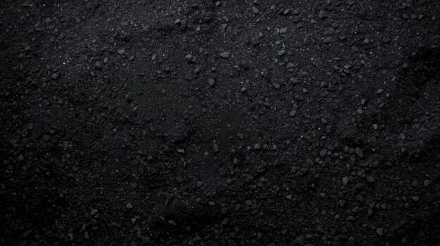 An overhead dark black background shows a rough texture of coal with small and large pieces together, perfect for industrial concept shots. photo