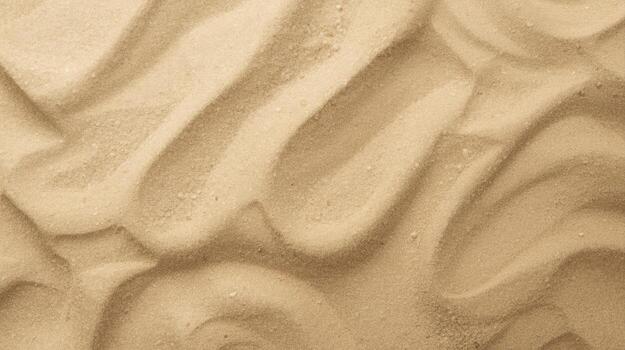 An overhead close up shows wavy patterns in the sand with tan color and smooth textured surface on a natural sunny desert background. photo