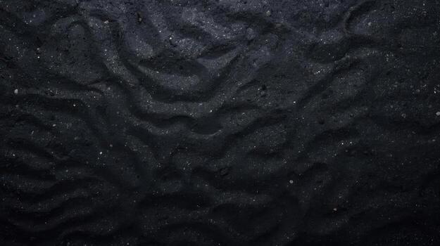Dark textured surface with wave-like patterns and scattered pebbles creates a mysterious and abstract background for graphic designs. photo