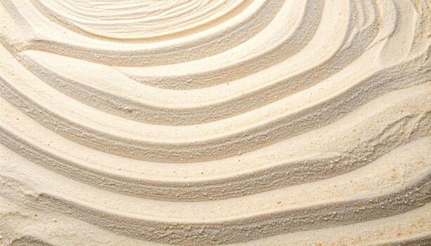 The rhythmic patterns are beautifully drawn in the sand, creating soft curving lines on a beige s symbolizing mindfulness and tranquility. photo