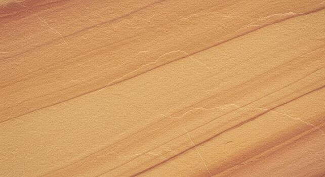 The sandstone texture exhibits warm tones and diagonal striations creating a natural pattern with subtle variations in color and surface detail. photo