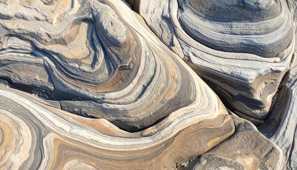 Close up shot of layered sedimentary rock formations showcasing intricate swirling patterns and textures of beige, gray, and white bands perfectly. photo